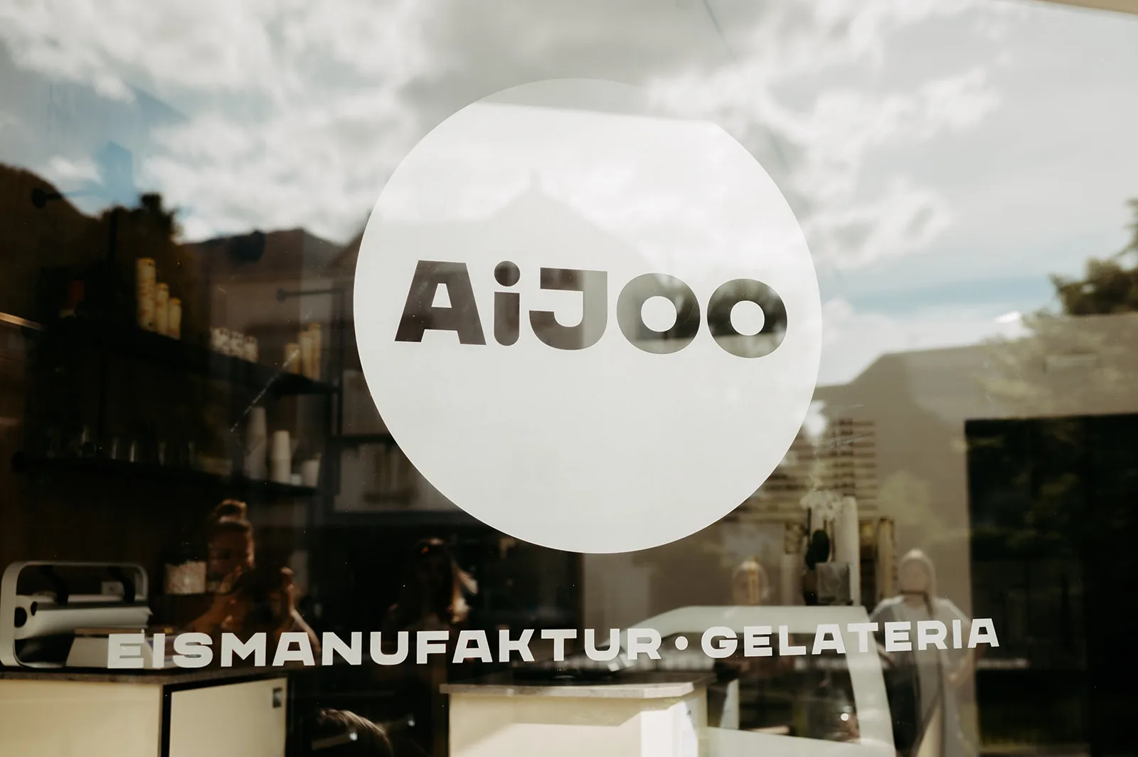 AiJOO-Logo auf der Schaufensterscheibe der Gelateria