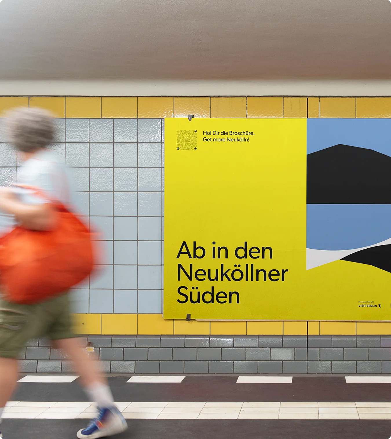 U-Bahn-Szene mit gelbem Kampagnenplakat „Ab in den Neuköllner Süden“