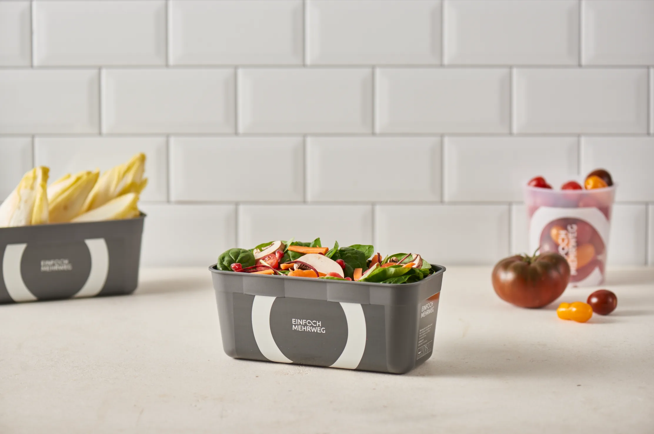 Graue Mehrwegschale mit Salat auf der Küchenzeile