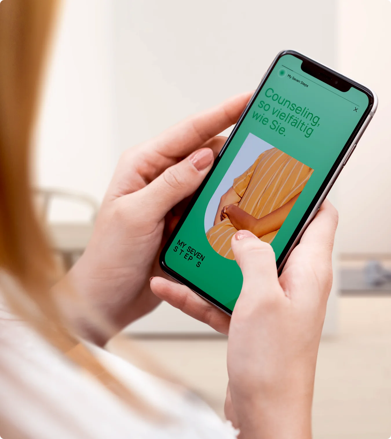 Hand hält ein Smartphone mit der grünen My-Seven-Steps-App