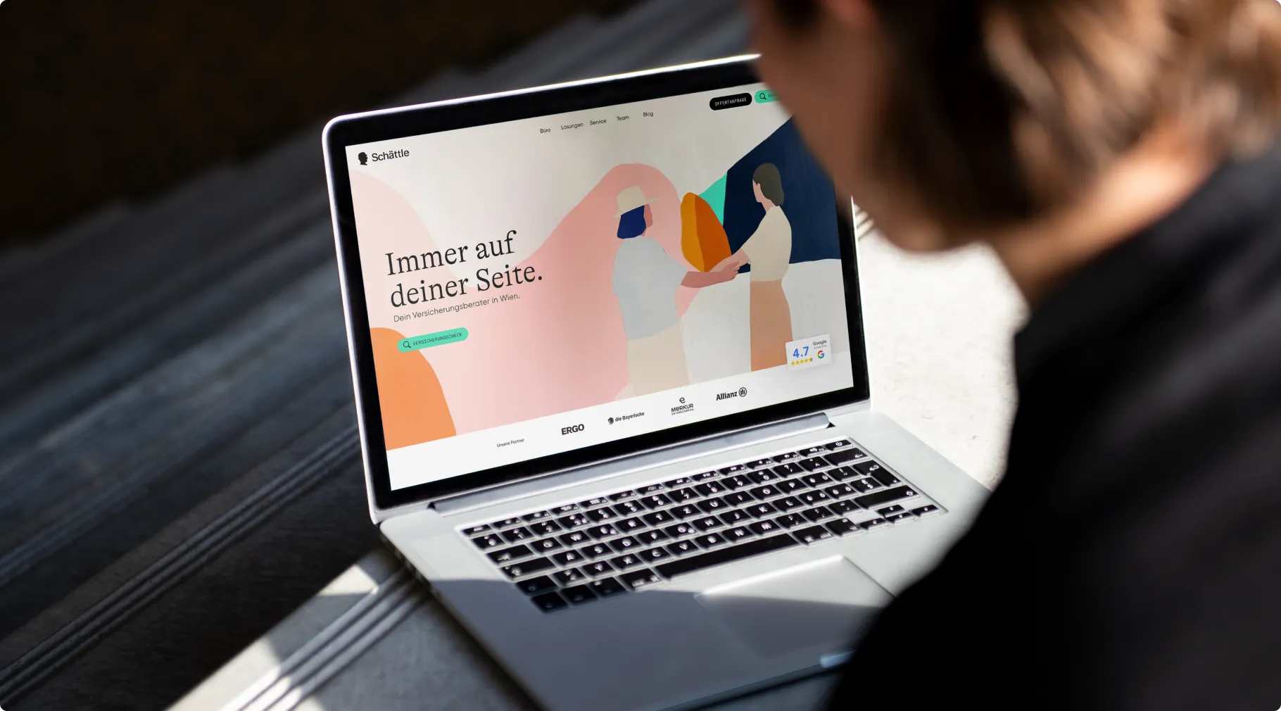 Hand holding a smartphone with the new Schättle website